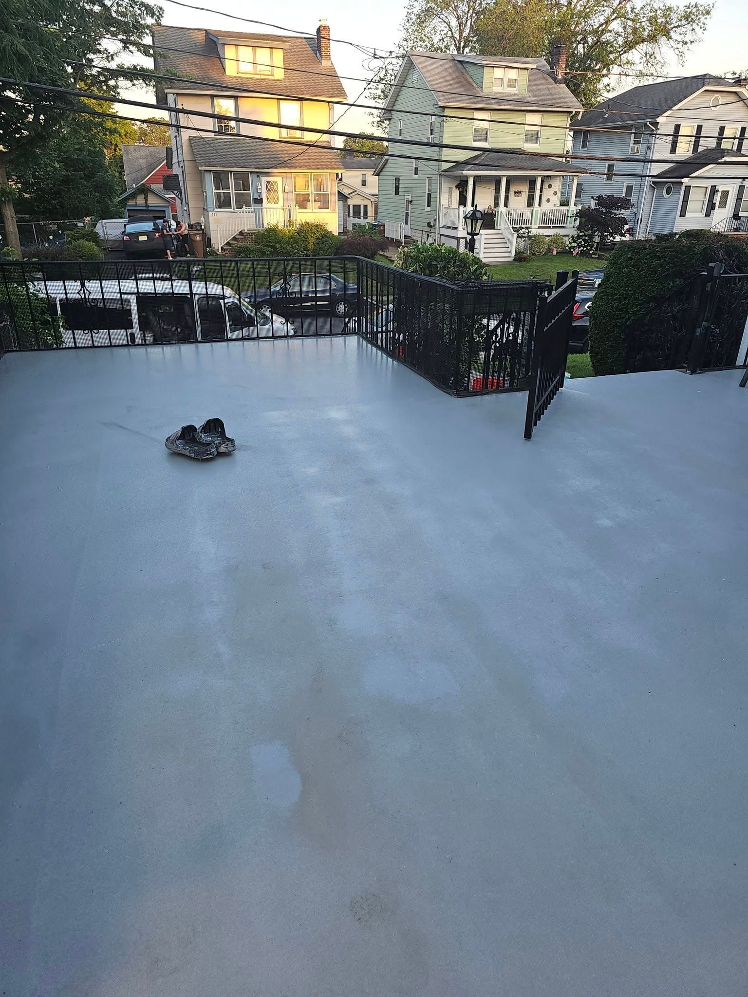 A pair of shoes is laying on the ground on a concrete deck.