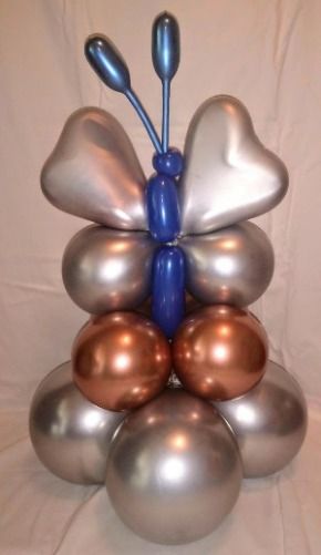 A butterfly made out of balloons is sitting on top of a pile of balloons.