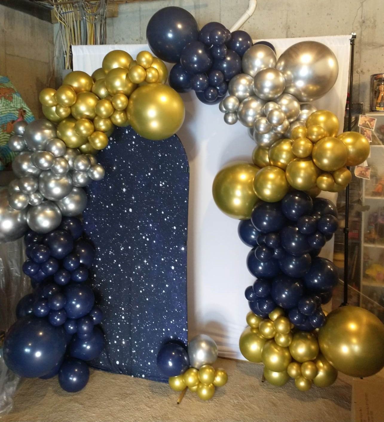 A bunch of blue and gold balloons are sitting on the floor