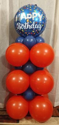 A stack of red and blue balloons with a happy birthday balloon in the middle.