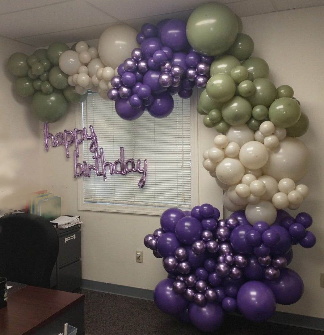 A bunch of purple and green balloons with the words happy birthday written on them