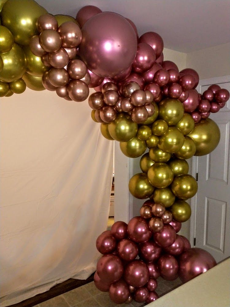 A bunch of balloons are hanging from the ceiling in a room.