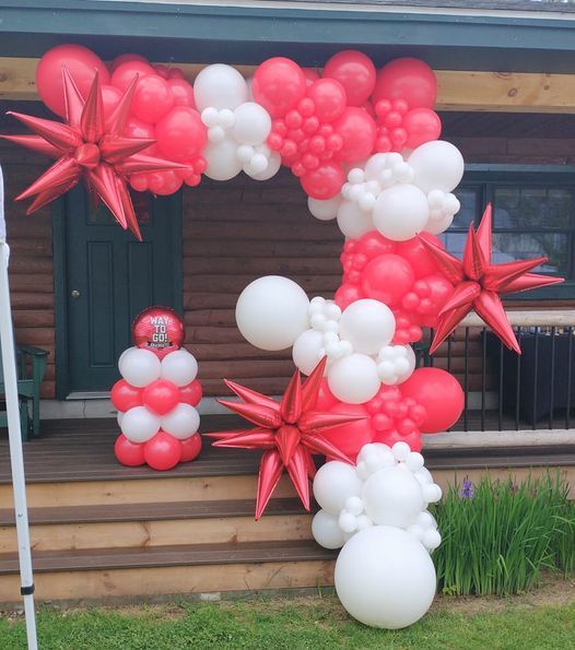 A bunch of red and white balloons on a porch