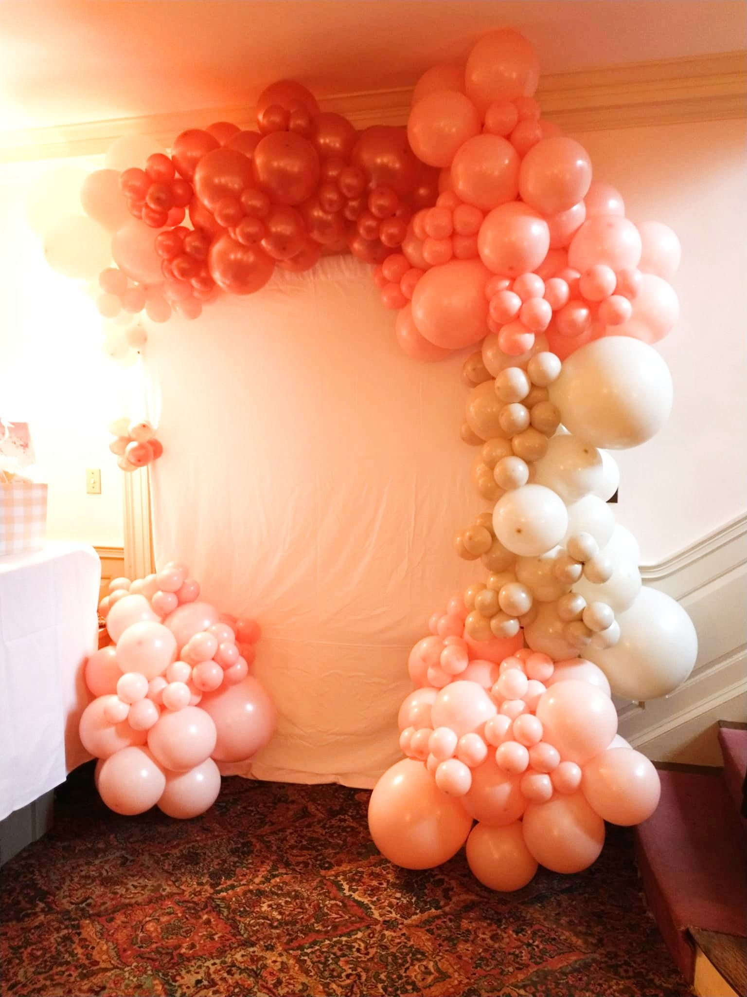 A room filled with lots of pink and gold balloons.