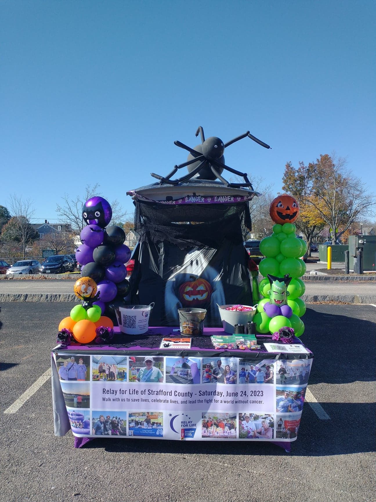 A trunk decorated for halloween with balloons and a spider on top.