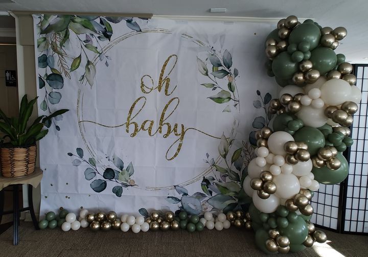 A room filled with balloons and a sign that says `` oh baby ''.