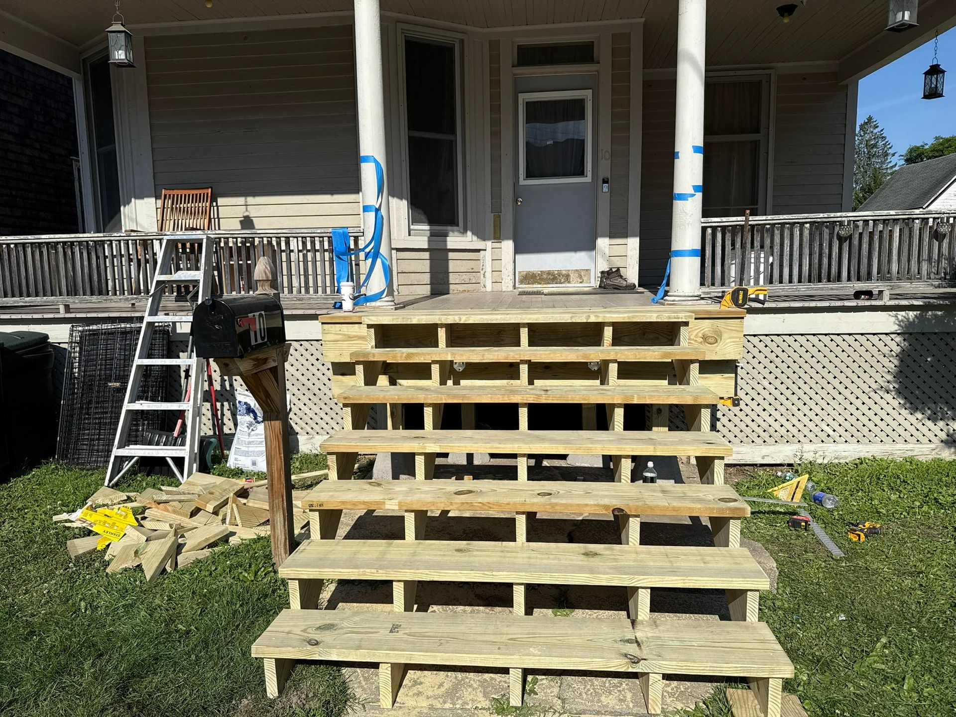 Newly constructed wooden steps leading up to the porch of a house.