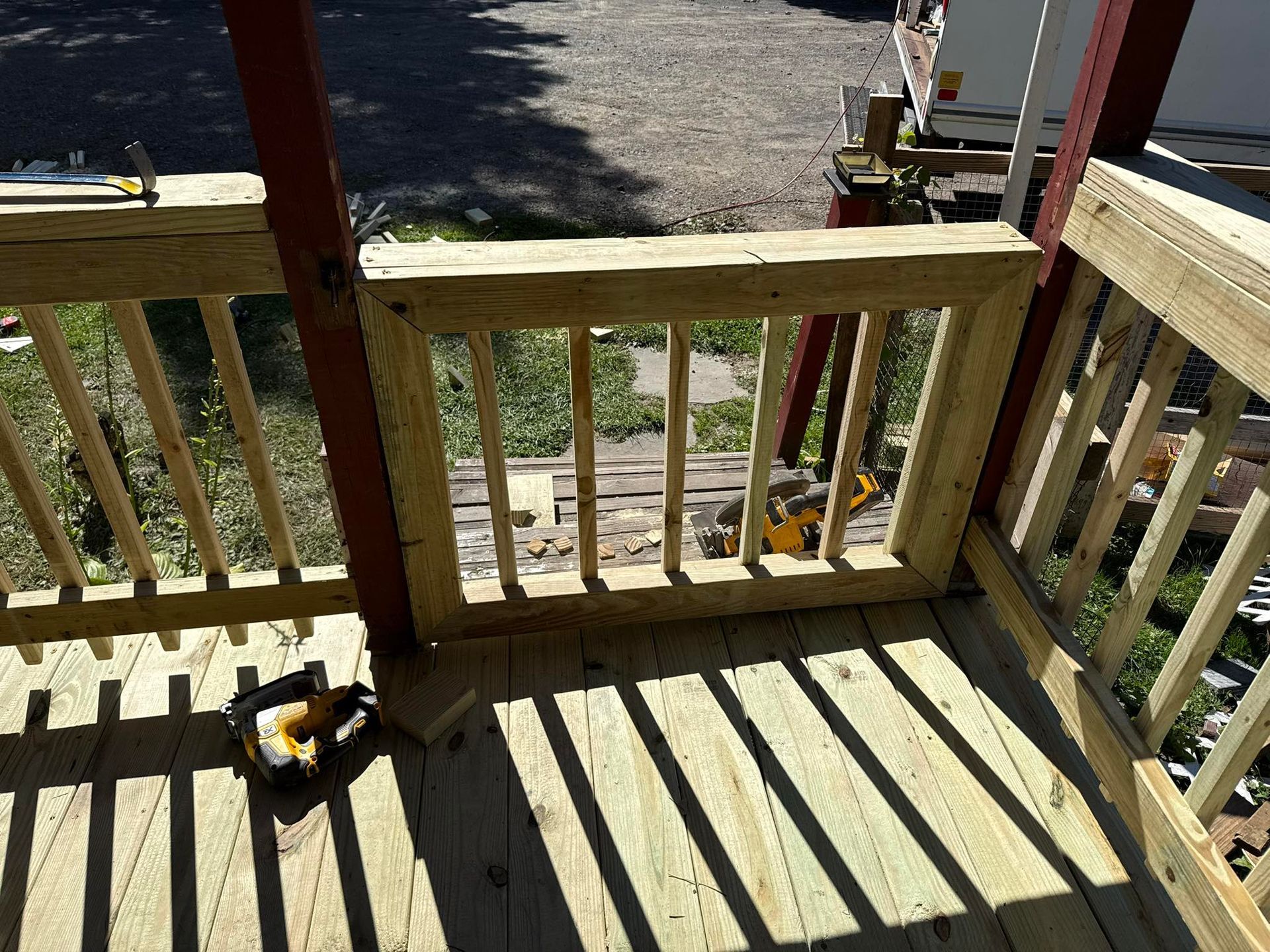 Wooden deck with railings under construction, tools visible.