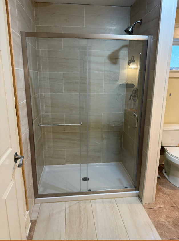 White kitchen with cabinets, stove, microwave, and sink under a window.