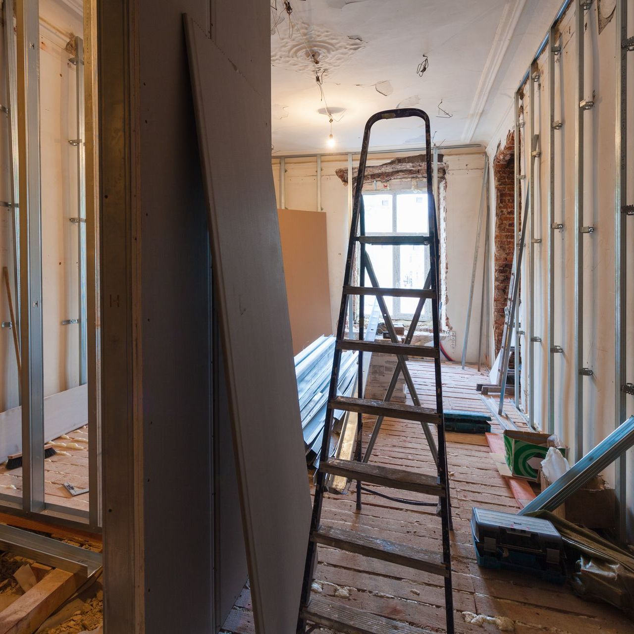 A ladder is in the middle of a room under construction