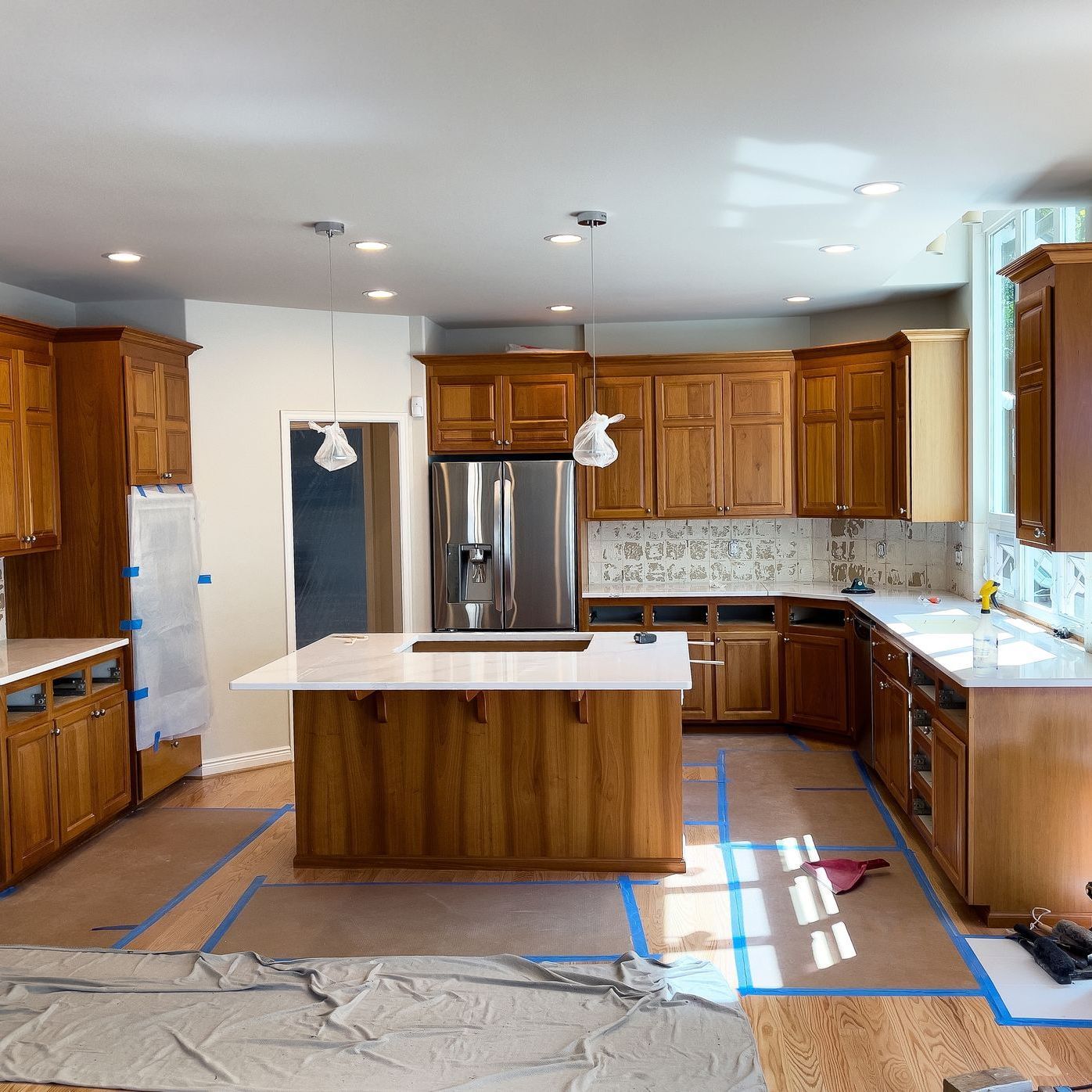 A kitchen with wooden cabinets and a stainless steel refrigerator