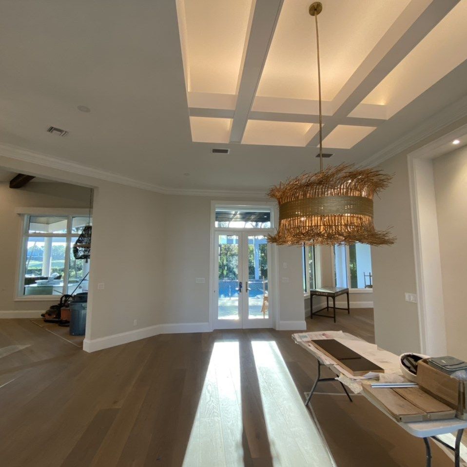 An empty room with a chandelier hanging from the ceiling