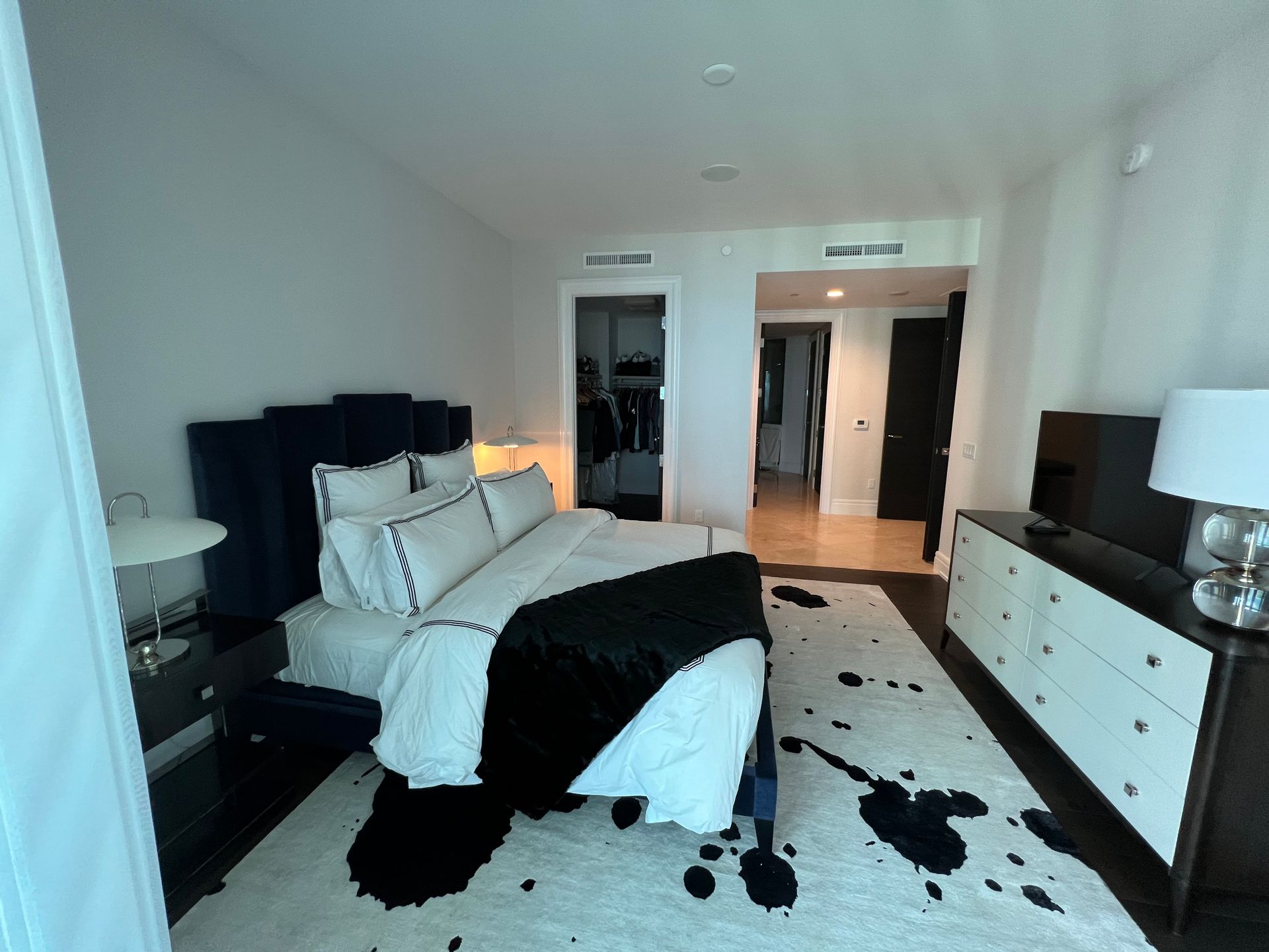 Bedroom with a blue bed, white and black decor, a closet, and a dark dresser.