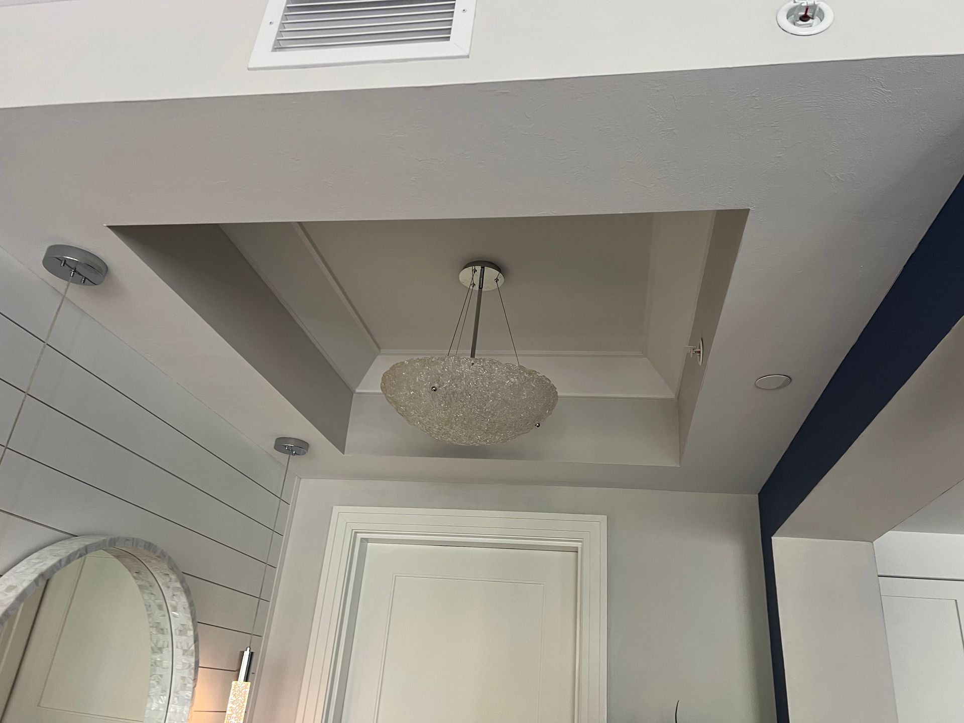 Bathroom ceiling with a chandelier, recessed lighting, and air vent.