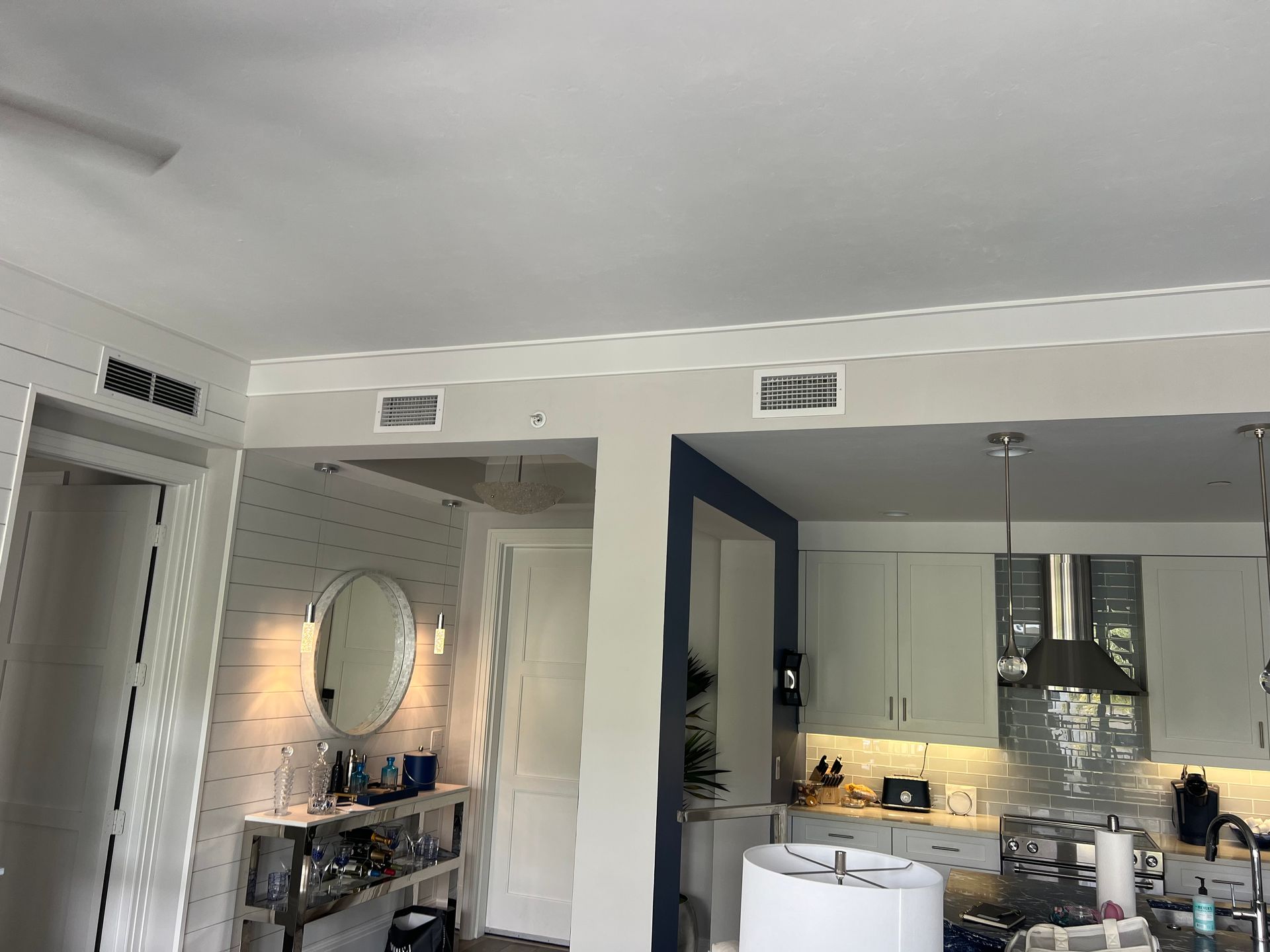 Interior view of a kitchen and living area with white walls, cabinets, and ceiling.