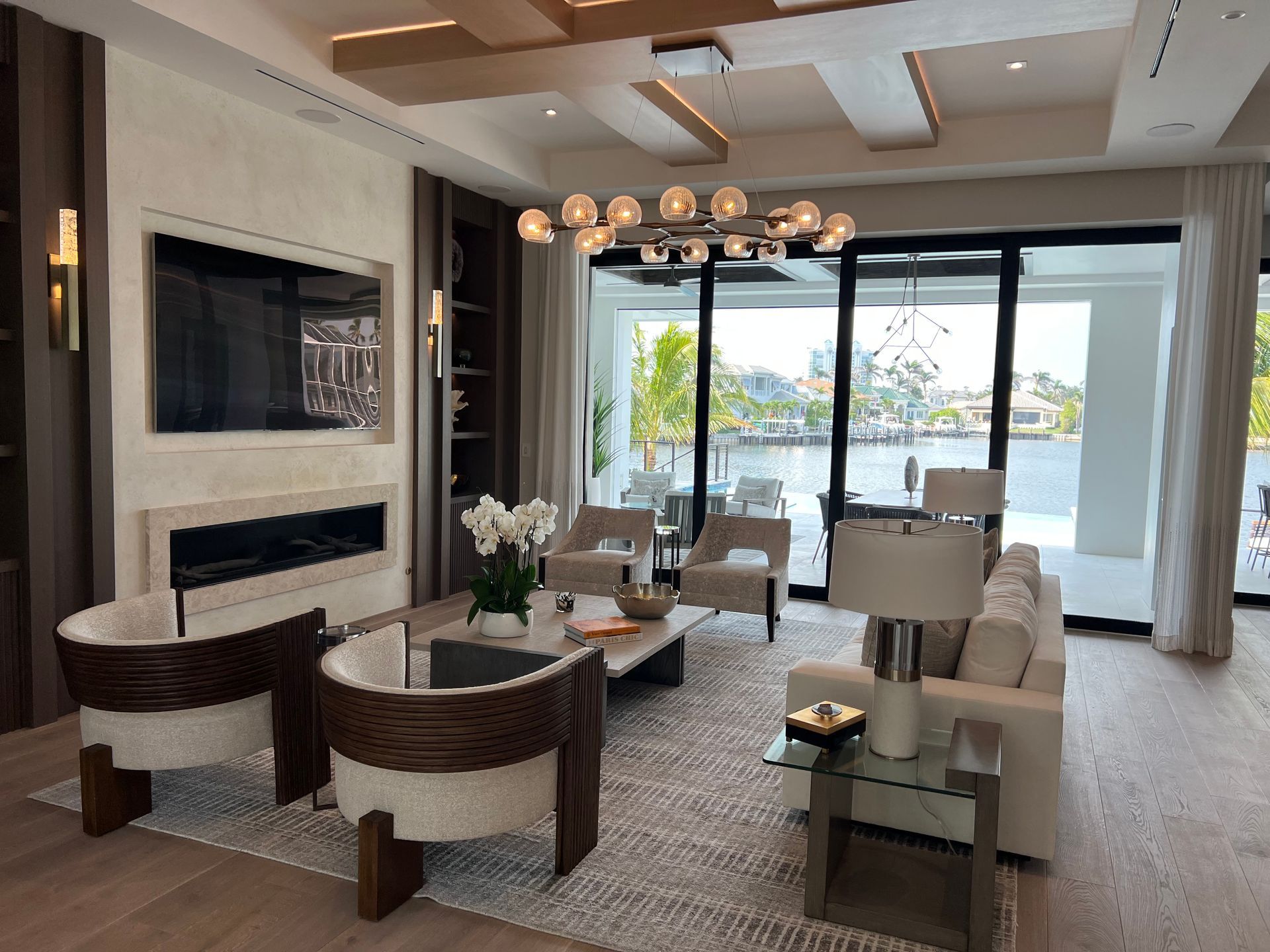 Living room with modern furniture, fireplace, and waterfront view.
