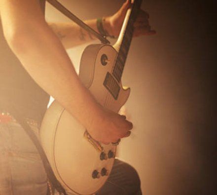 man playing electric guitar on stage