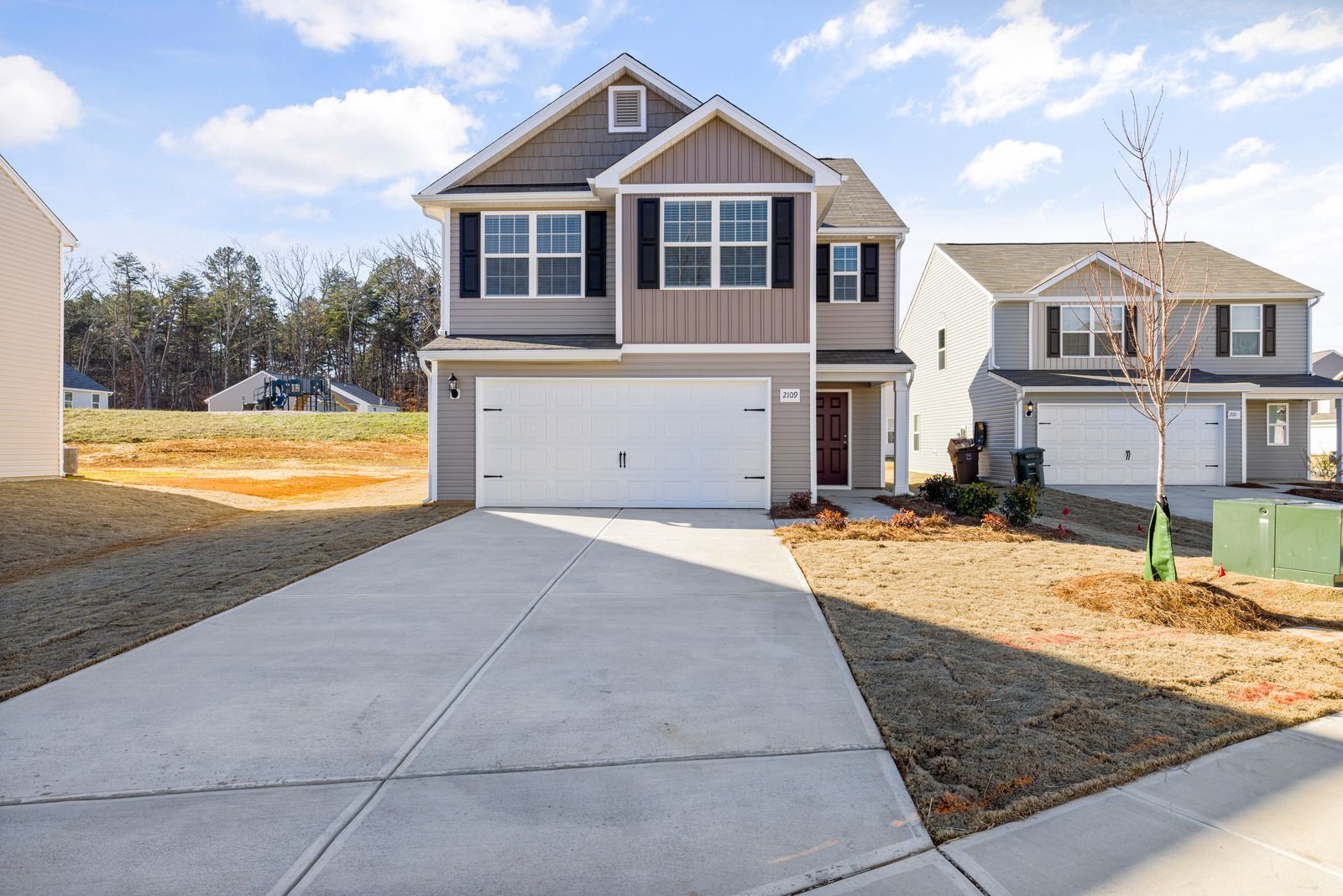 A house with a garage and a driveway in front of it.