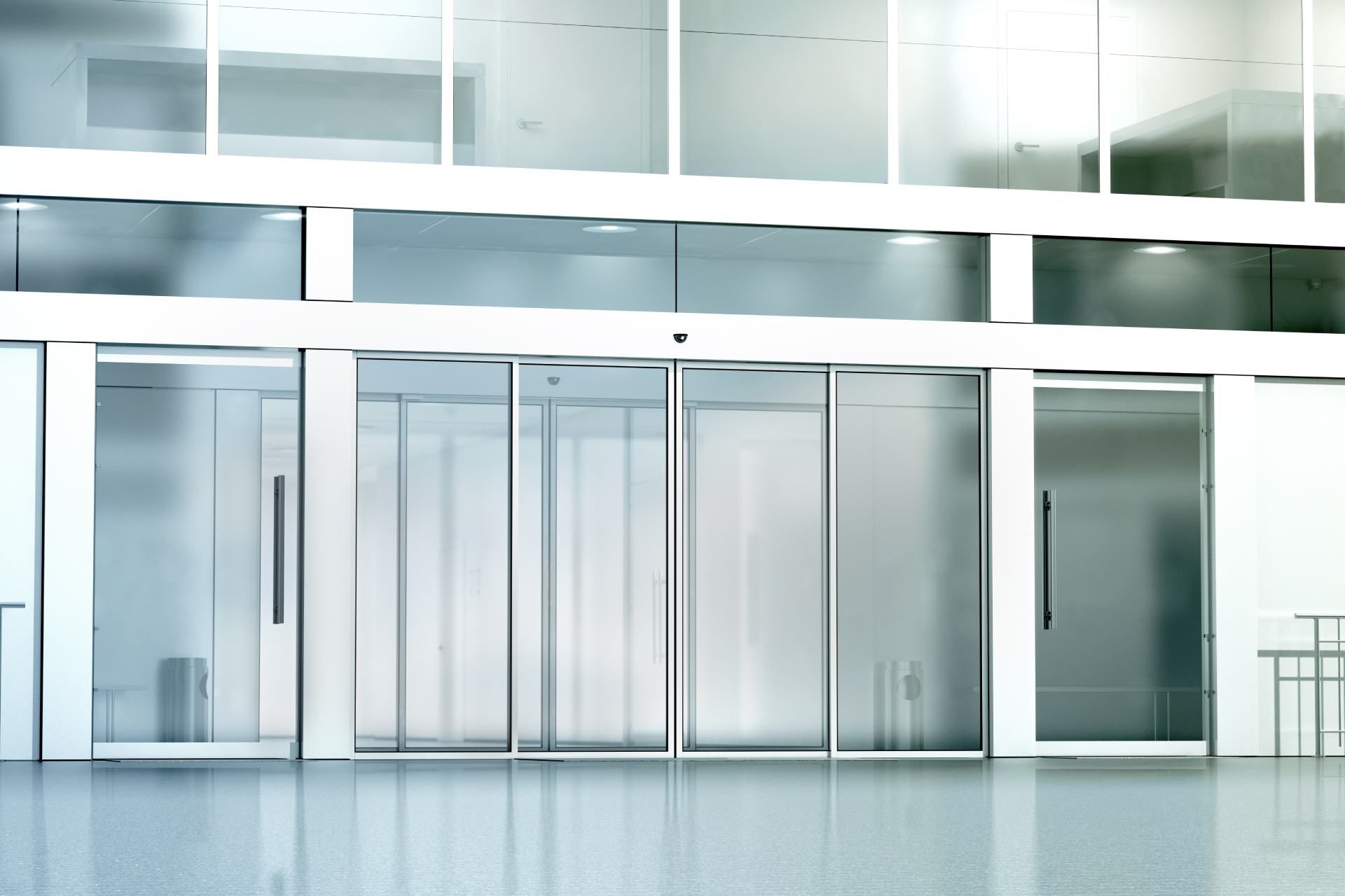 Modern building entrance with automated sliding glass doors and frosted glass panels.