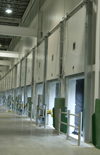 Loading dock doors along a warehouse wall, metal and green.