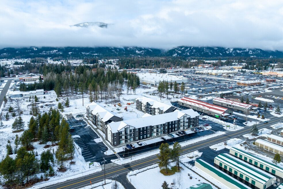 An aerial view of a city covered in snow with mountains in the background.