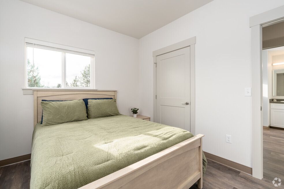 A bedroom with a king size bed and a window.