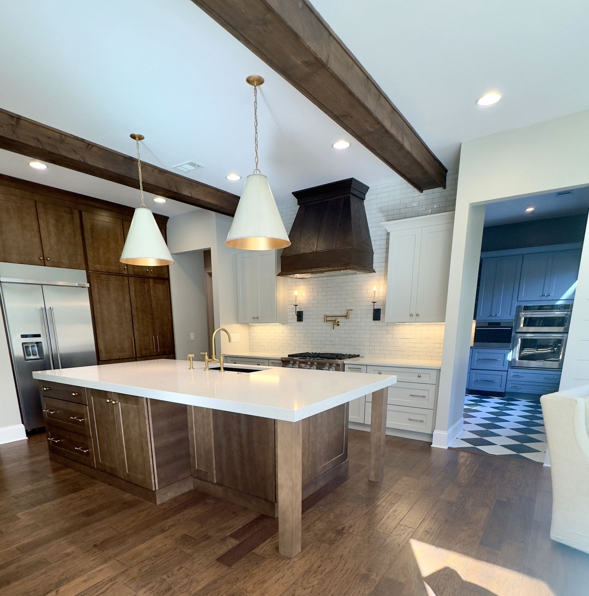 Kitchen with wood cabinets, white countertops, and pendant lights.