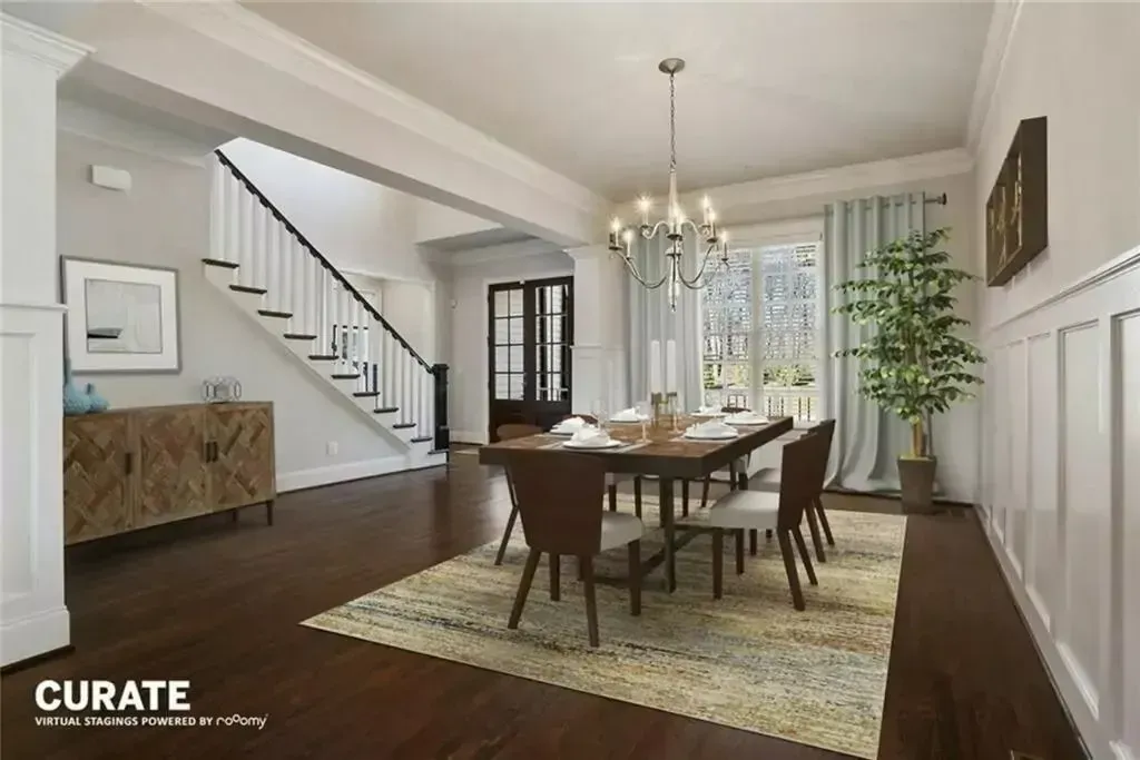 Dining room with table, chairs, rug, and view to stairs and doorway. Light blue curtains and chandelier.