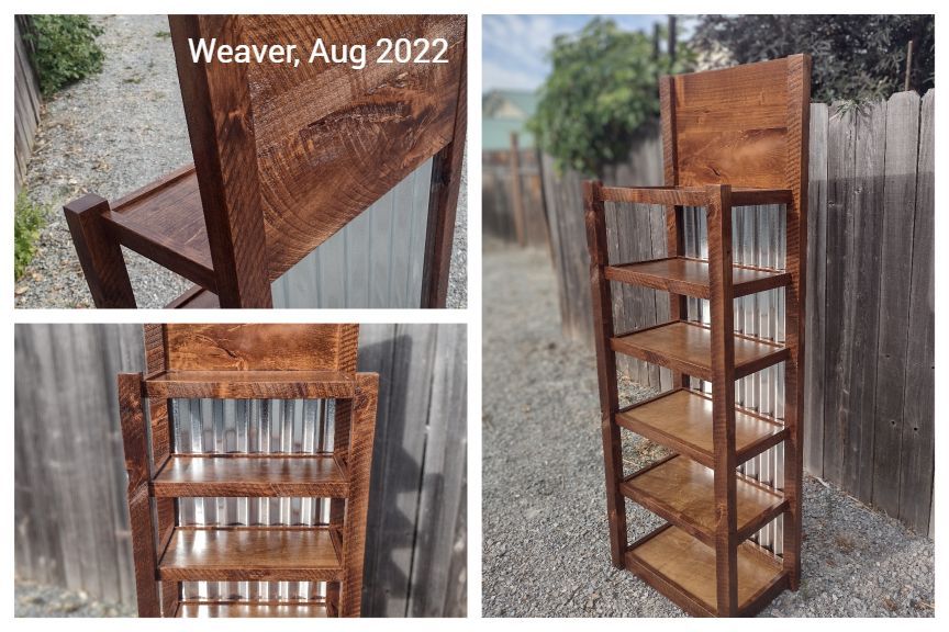 A wooden shelf is sitting in front of a fence.