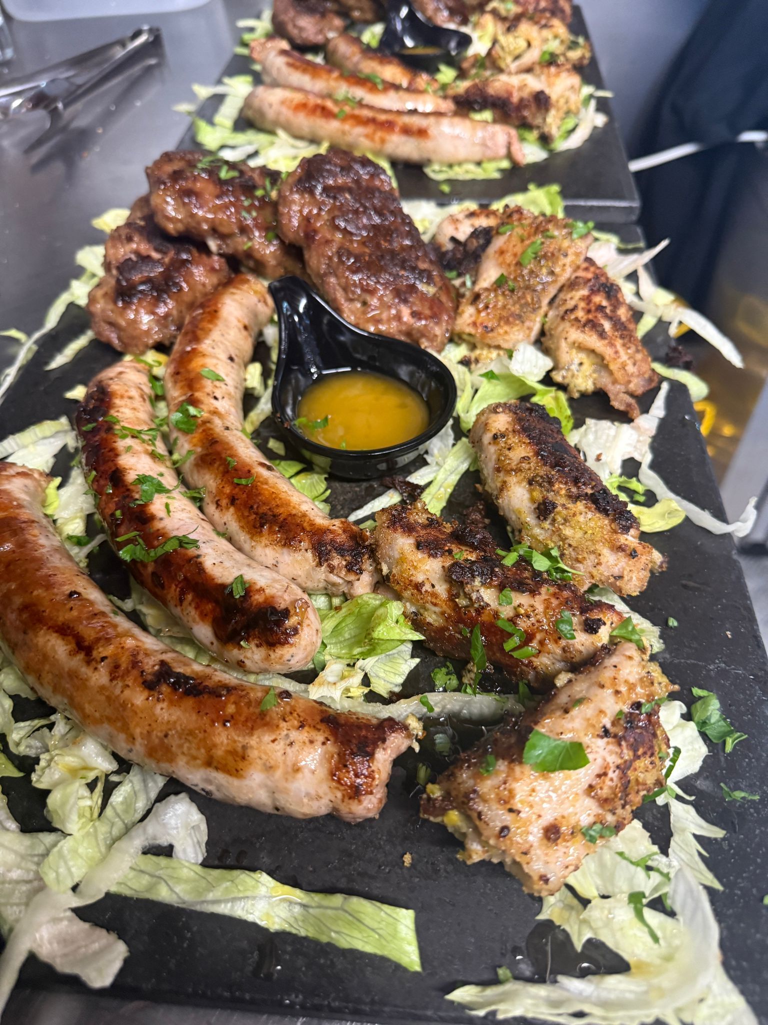 Piatto di carne alla griglia con verdure e salsa.