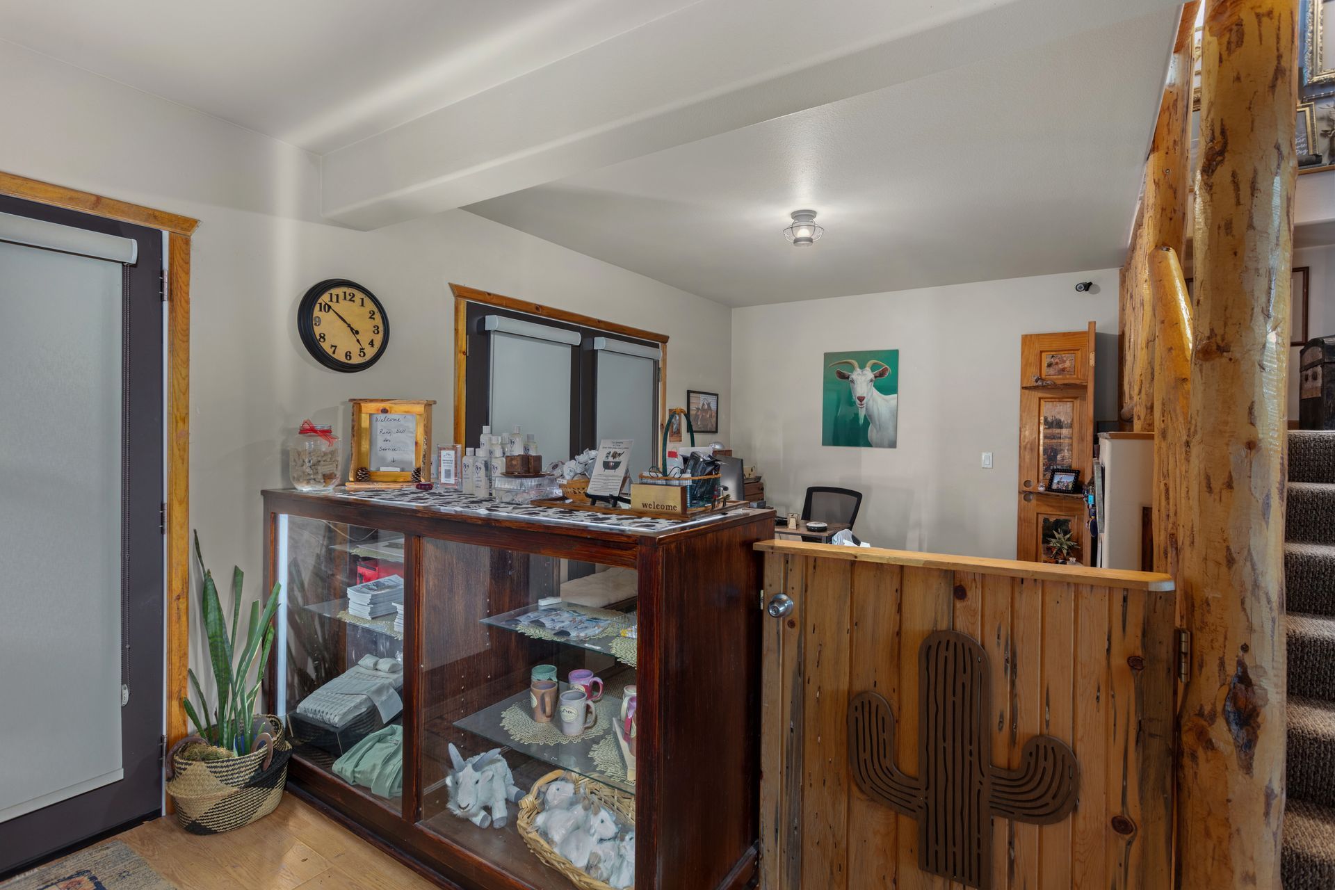 Wooden porch with two folding chairs overlooking a scenic landscape of trees and hills under a cloudy sky.