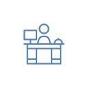 Person at a reception desk with a computer and bell.