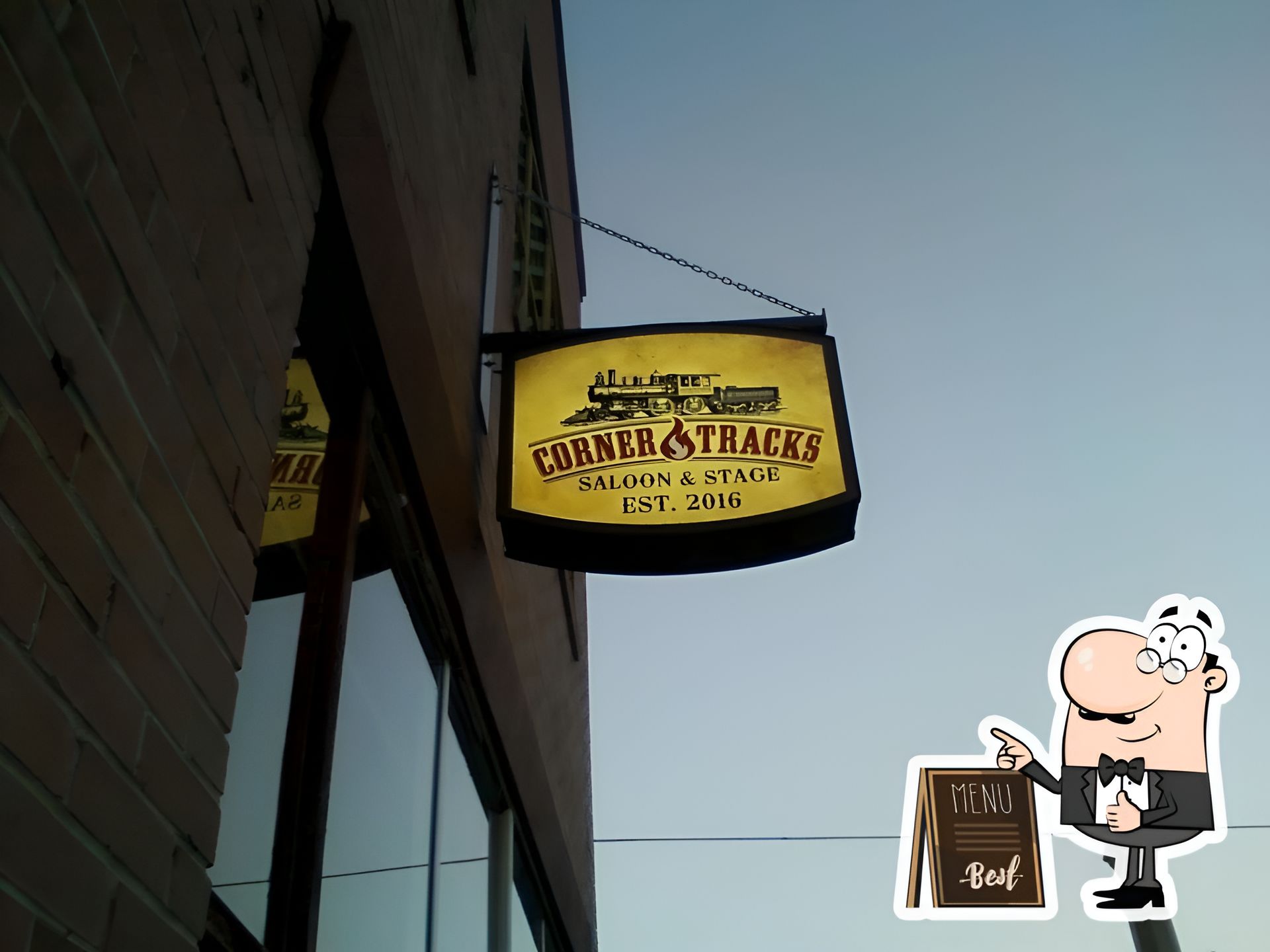 A sign that says cobra tracks hangs from the side of a building