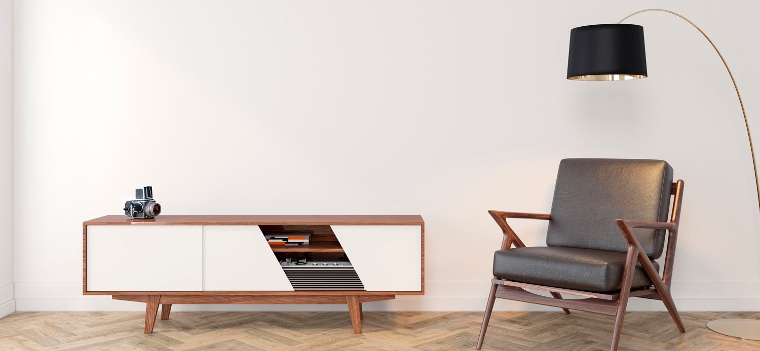 Living room interior with a mid-century modern style. A cabinet, chair, lamp, and camera are present. White walls and wooden floor.