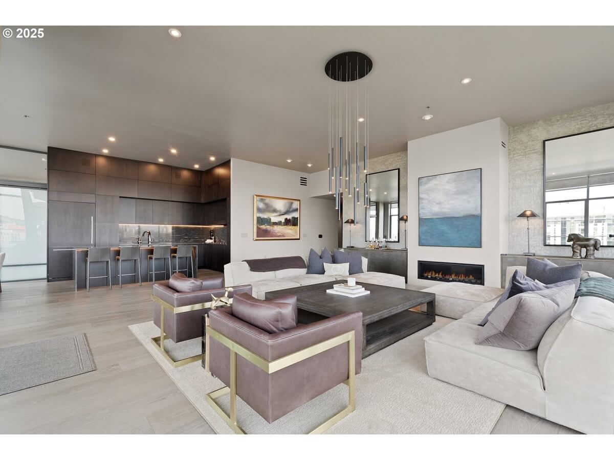 Modern condo living room with neutral colors, fireplace, and contemporary furniture.