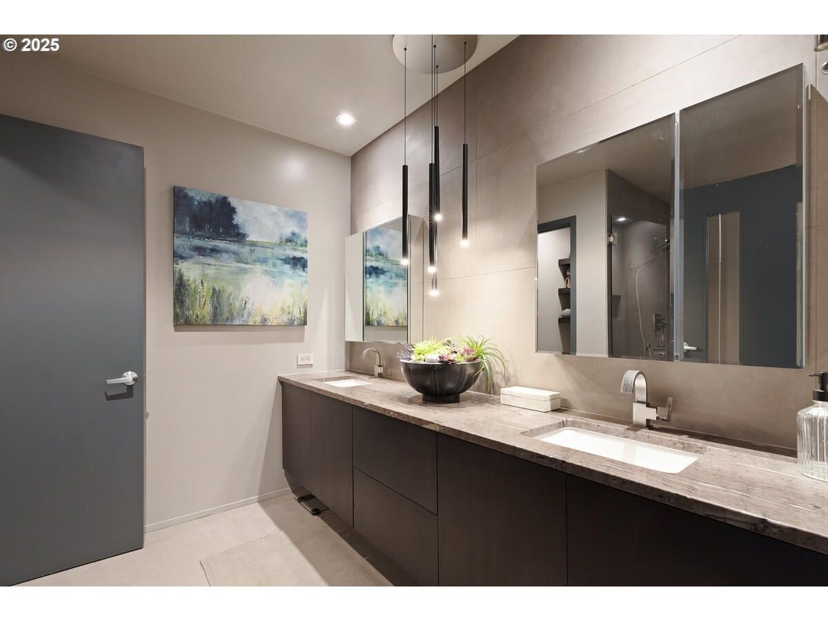 Modern bathroom with long vanity, two sinks, and abstract art.
