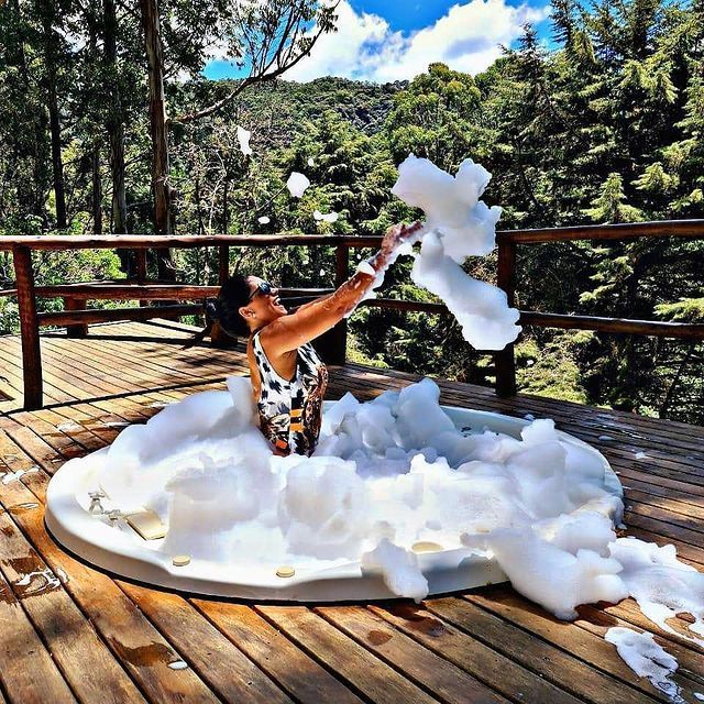 Uma mulher está deitada em uma jacuzzi cheia de espuma