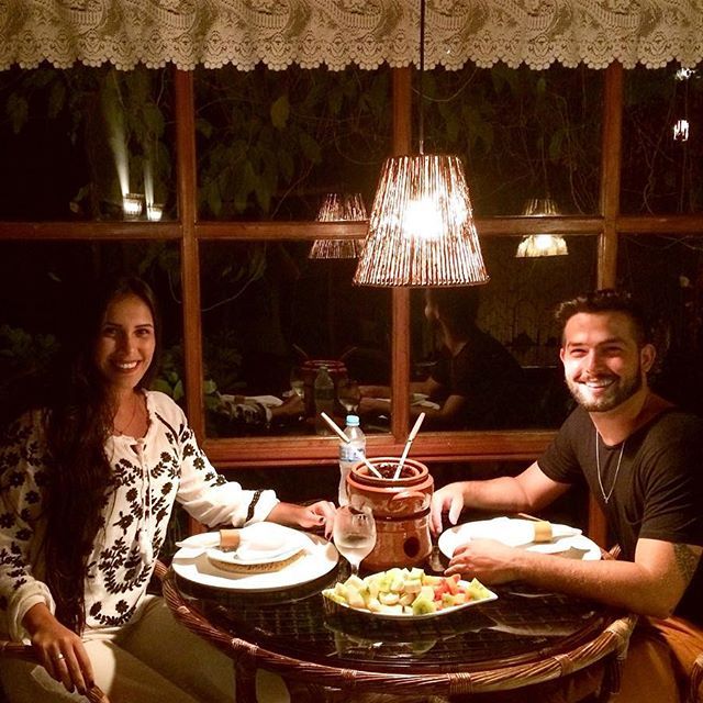 Um homem e uma mulher estão sentados à mesa com pratos de comida