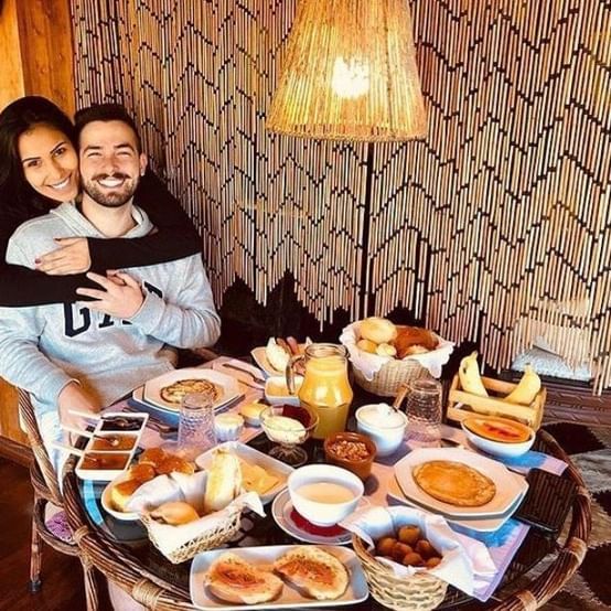 Um homem e uma mulher estão sentados à mesa com comida