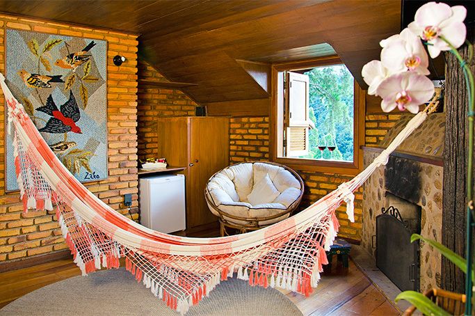 Uma sala de estar com uma rede e uma cadeira