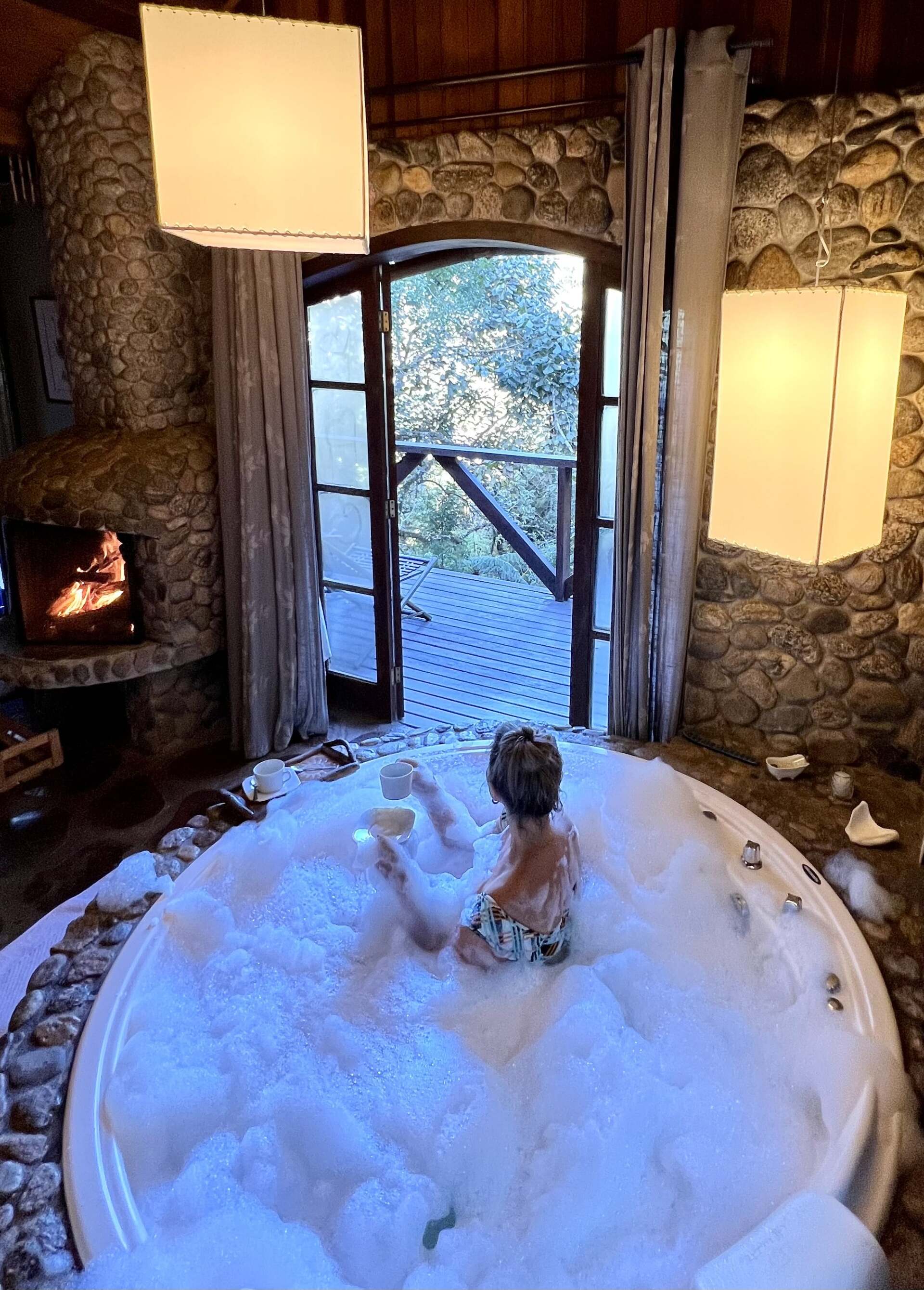 Uma mulher está sentada em uma jacuzzi cheia de espuma.