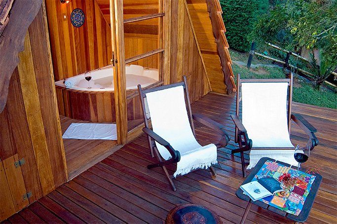 Um deck de madeira com duas cadeiras e uma mesa