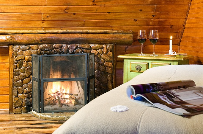 Um quarto com lareira e uma revista na cama