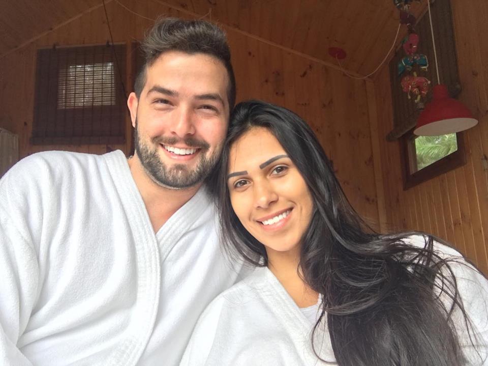 Um homem e uma mulher estão posando para uma foto vestindo roupões de banho.