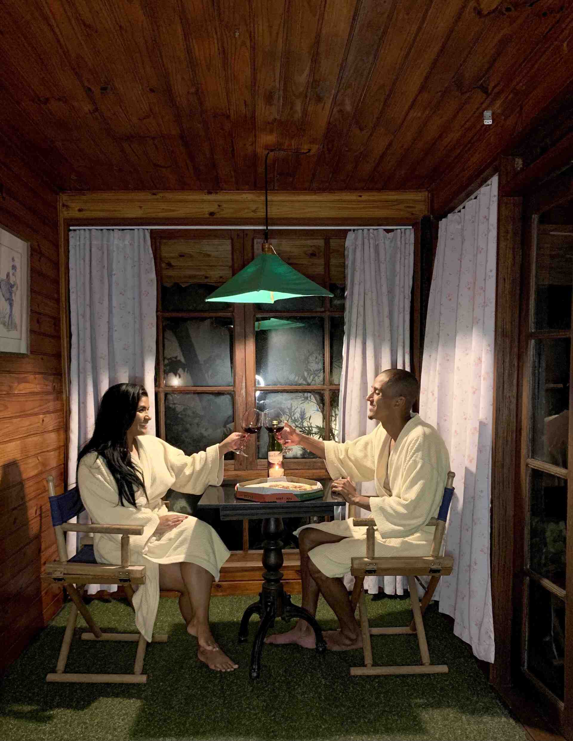 Um homem e uma mulher estão sentados à mesa bebendo vinho.