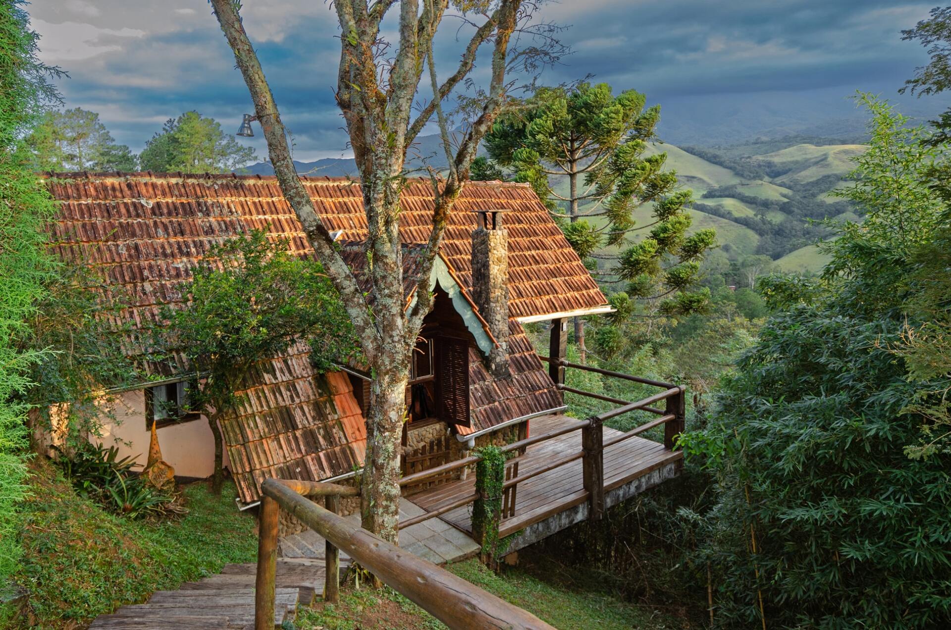 Uma pequena casa com um deck de madeira no meio de uma floresta.