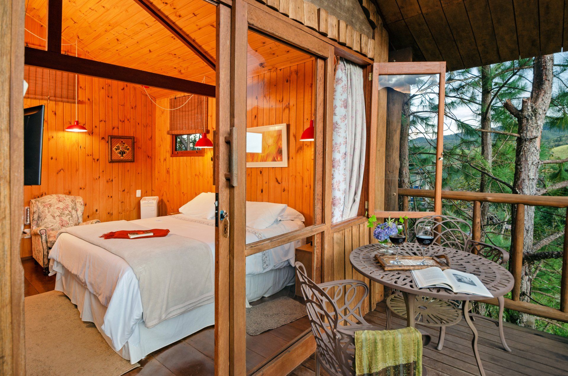 Um quarto com uma cama e uma mesa na varanda.