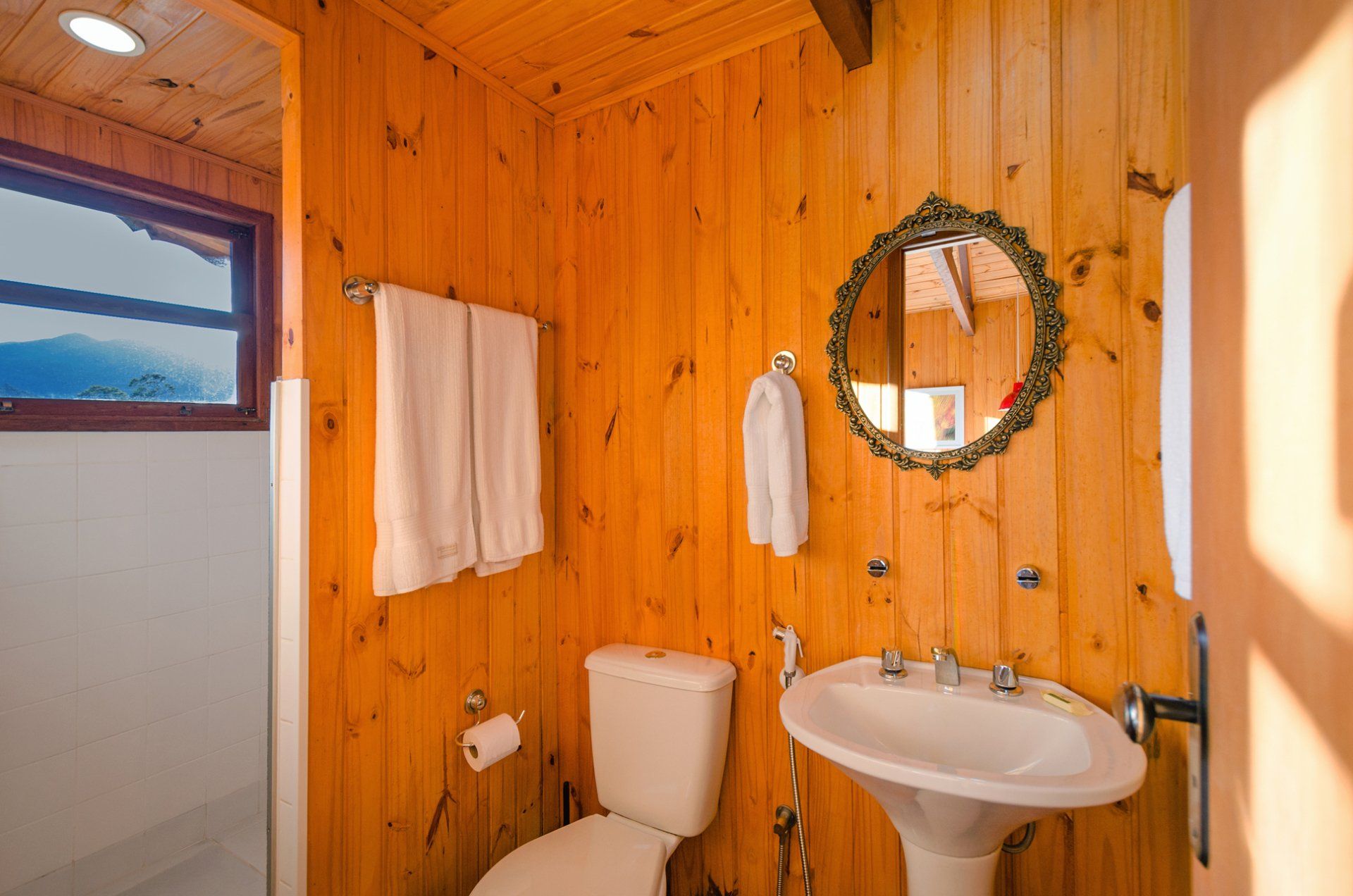 Um banheiro com vaso sanitário, pia e espelho.