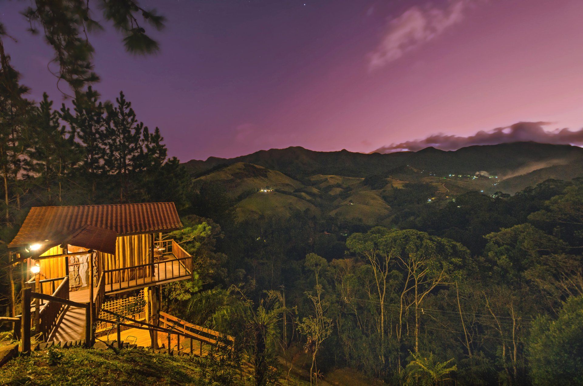 Uma casa no meio de uma floresta com montanhas ao fundo