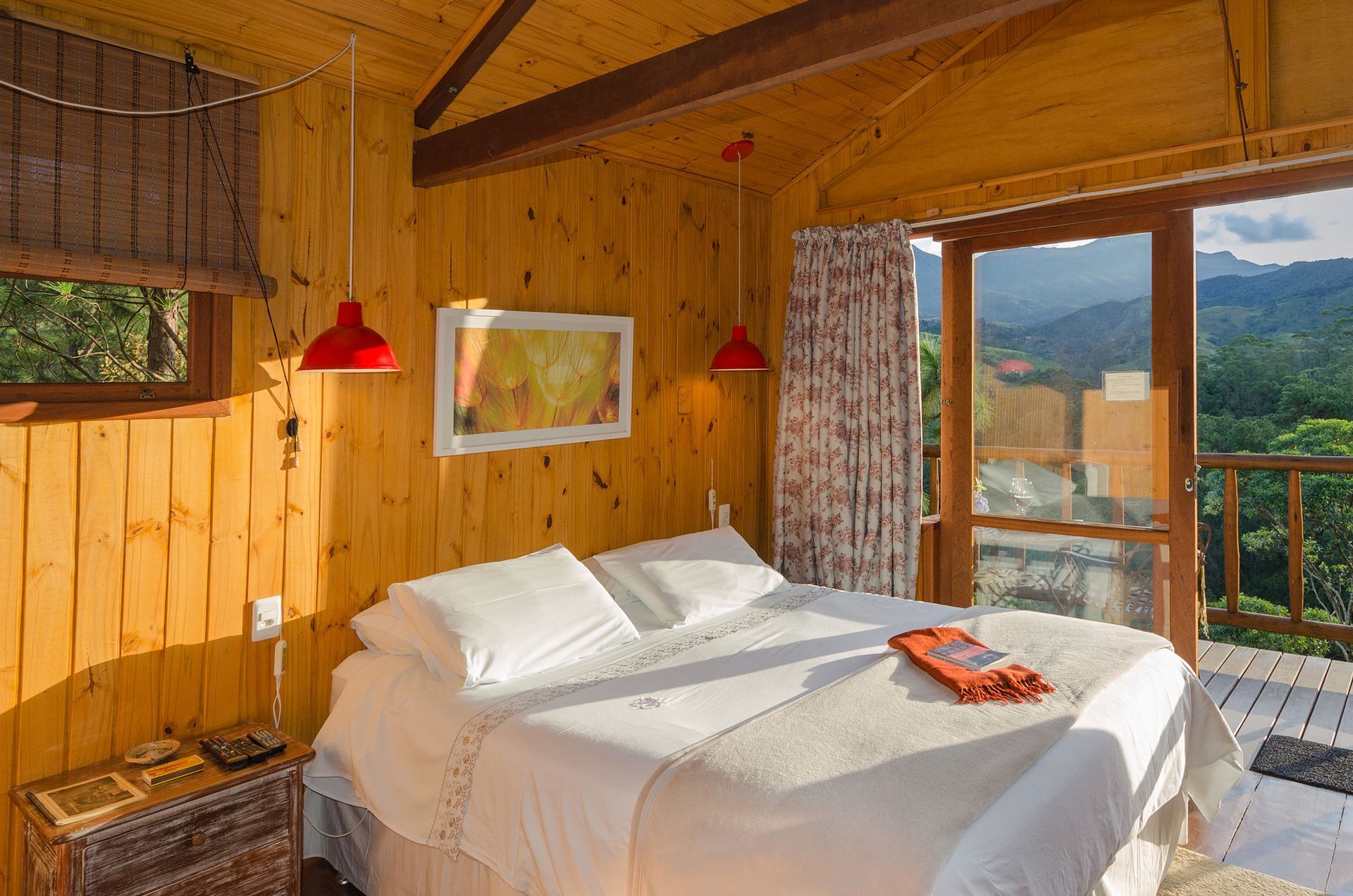 Um quarto em uma cabana de madeira com uma cama grande e vista para as montanhas.